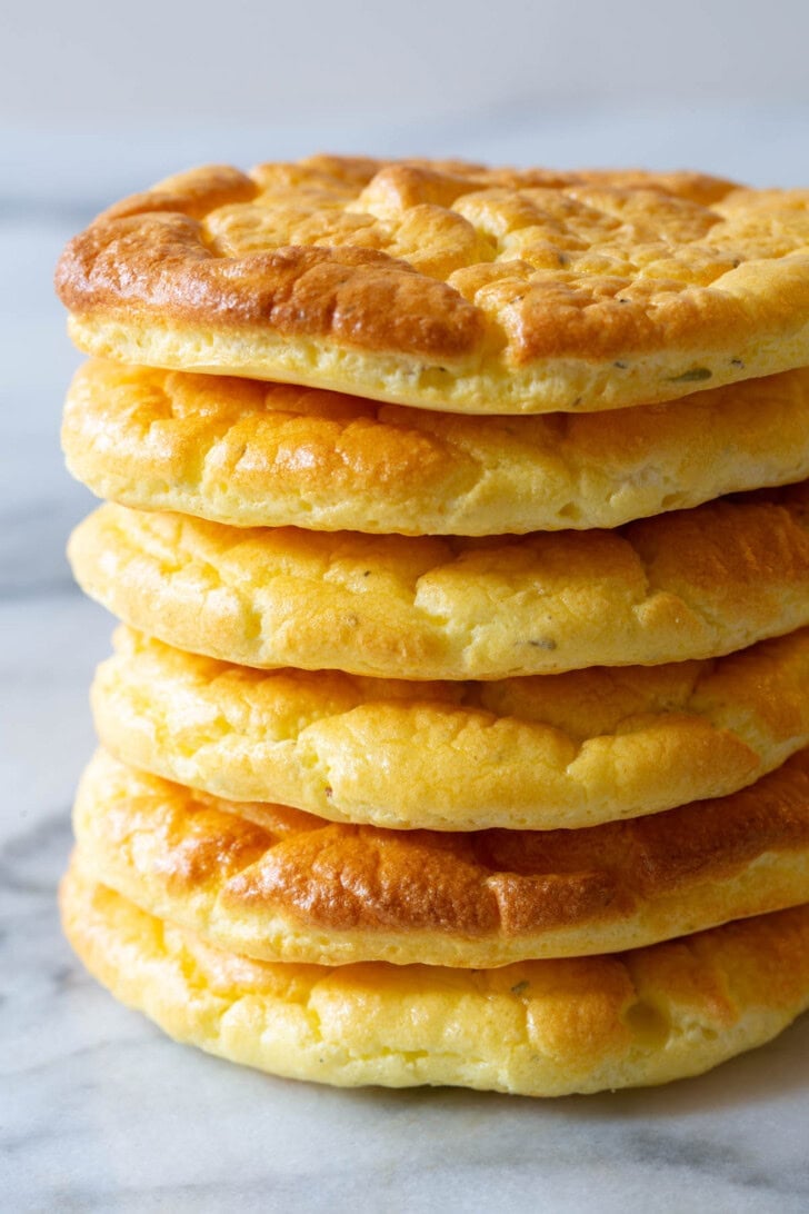 Cloud Bread #ASpicyPerspective #LowCarb #GlutenFree #GrainFree #Keto #CloudBread #CloudBreadRecipe #KetoCloudBread #NoCarbBread Stack of cloud bread on a marble surface.