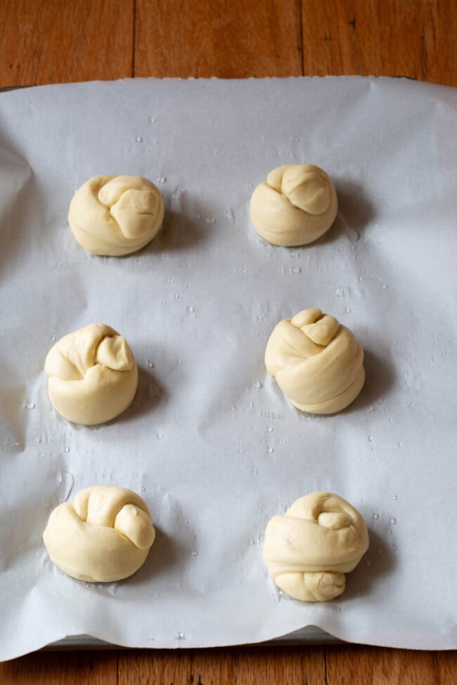 Garlic knots on a baking sheet before being baked.