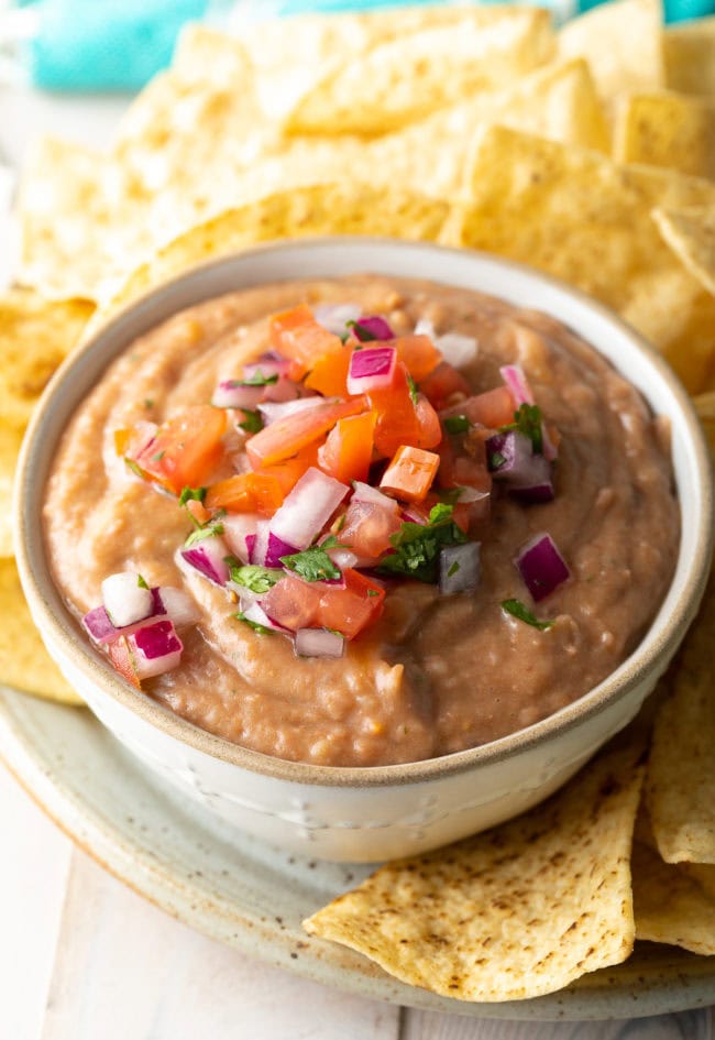Bean dip topped with pico de gallo and served with chips.